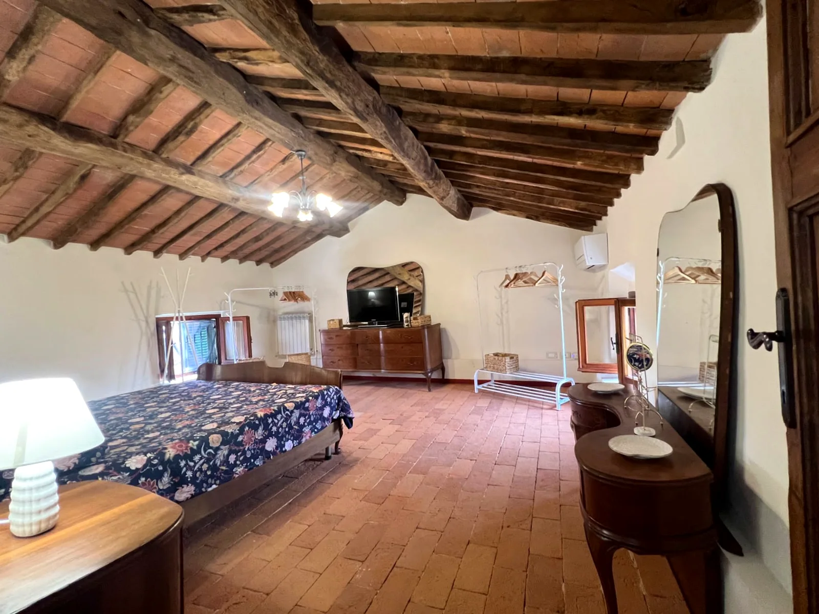 Large attic bedroom with exposed beams at Villa Versilia